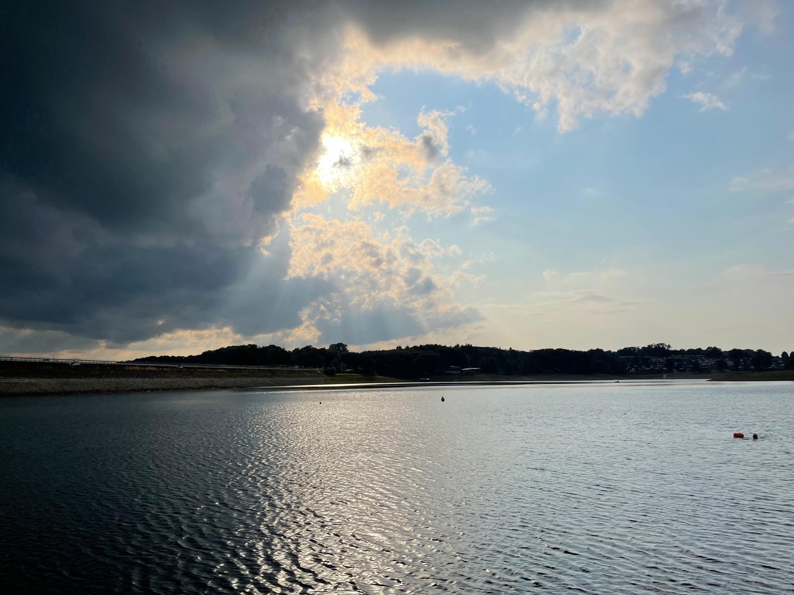 Abendstimmung über einer Talsperre – Sonnenstrahlen brechen durch die Wolken